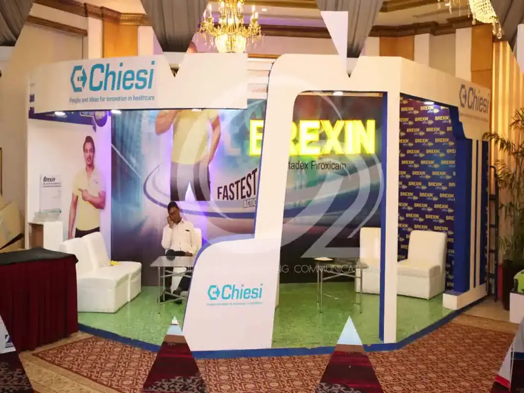 Footage from Pak Orthocon: a run of individually fabricated pharmaceutical exhibition stalls along a conference floor, each carrying its own brand, with seating areas and product displays built in.