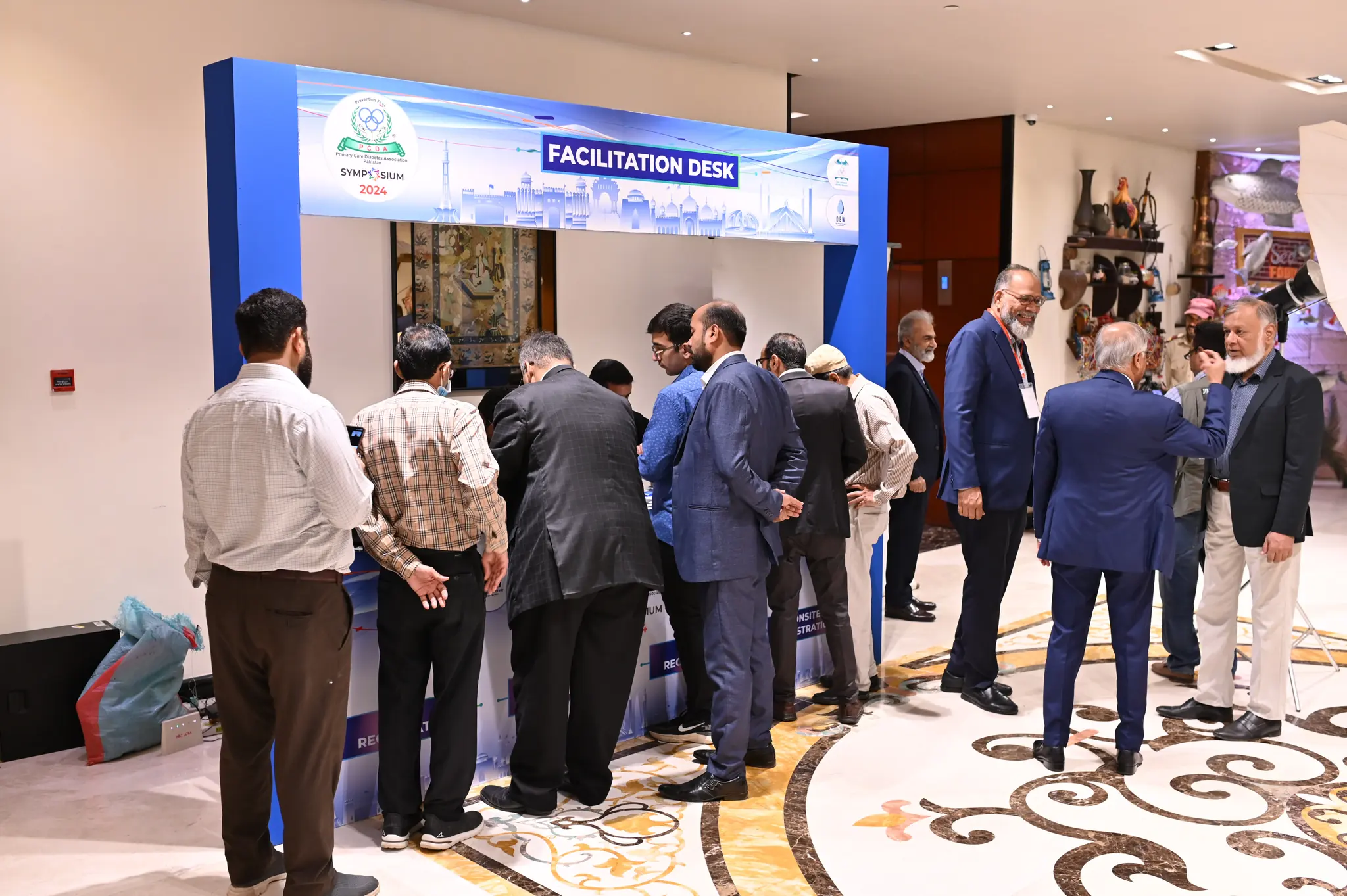Delegates arriving at a corporate symposium and gathering at a branded facilitation and registration desk.